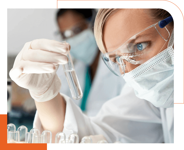 A woman in white lab coat holding a test tube.